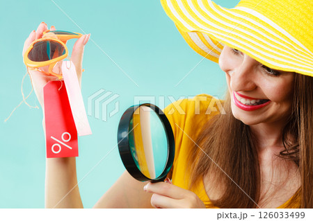 woman choosing glasses searching through magnifying glass woman choosing glasses searching through magnifying glass 126033499