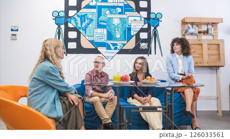 Colleagues sitting in a lounge area having a casual conversation over snacks. Colleagues sitting in a lounge area having a casual conversation over snacks. 126033561