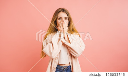 Shocked blonde woman covering her mouth with hands on pink background Shocked blonde woman covering her mouth with hands on pink background 126033746