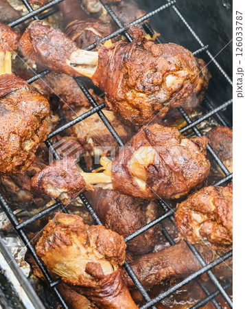 Smoky barbecue chicken legs grilled to perfection at a backyard gathering during summer Smoky barbecue chicken legs grilled to perfection at a backyard gathering during summer 126033787