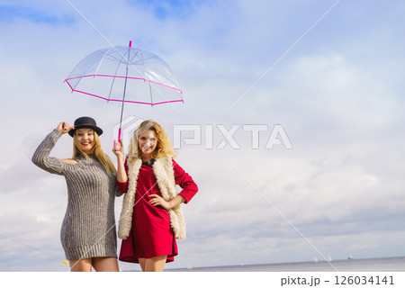 Two fashionable women and umbrella Two fashionable women and umbrella 126034141