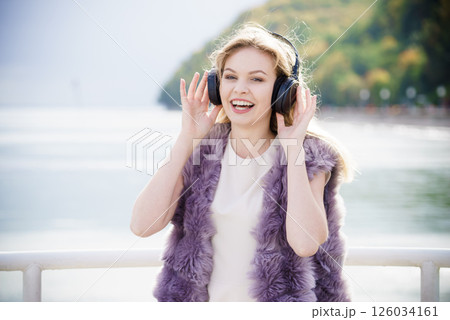 Happy woman wearing headphones outdoor 126034161
