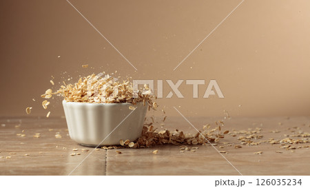 Oat flakes in motion on a beige background. 126035234