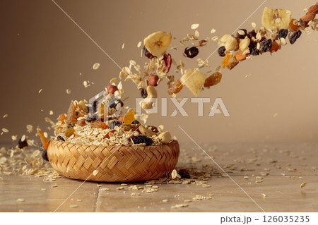 Muesli in motion on a beige background. Muesli in motion on a beige background. 126035235