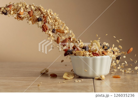 Muesli in motion on a beige background. 126035236