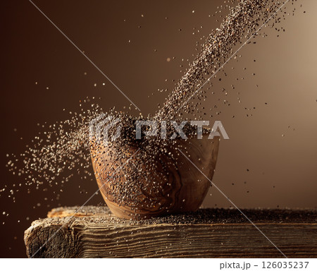 Chia seeds is poured into a wooden bowl. 126035237