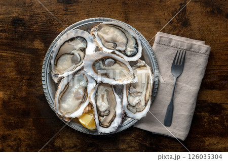 Fresh raw oysters on ice, overhead flat lay shot 126035304