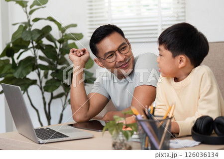 Homeschool learning session between father and son at a desk 126036134