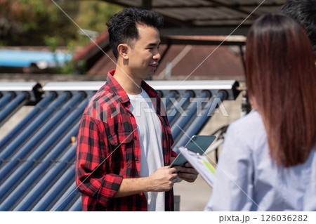 Client Interaction and Solar Energy Education. A technician shares insights on solar energy with clients during a site visit. Client Interaction and Solar Energy Education. A technician shares insights on solar energy with clients during a site visit. 126036282