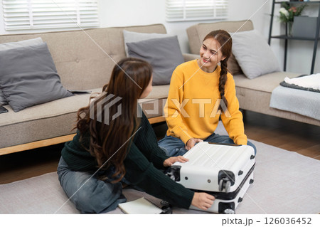 Creating travel memories as friends pack and chat joyfully at home 126036452