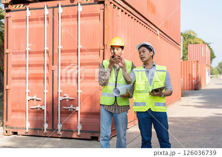 Engineers coordinating logistics and project plans at a shipping container yard 126036739