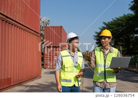 Strategic Planning. Engineers discussing logistics using a laptop at a site. 126036754