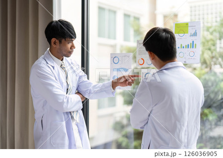 Team collaboration in healthcare: Doctors analyzing data charts Team collaboration in healthcare: Doctors analyzing data charts 126036905