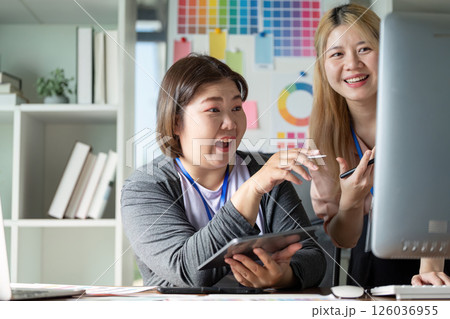 Diverse design team collaborating on a graphics project in a creative workspace. 126036955