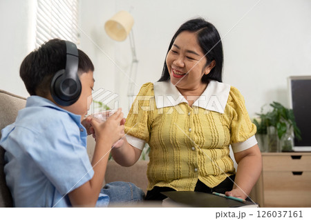 Back to School and Family Bonding. A mother and son share a drink, celebrating their connection. Back to School and Family Bonding. A mother and son share a drink, celebrating their connection. 126037161