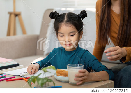Back to School and Morning Routine. A girl enjoying breakfast with her mother before heading to school. 126037215