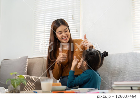Encouragement and Joy. A mother and daughter celebrate learning achievements. 126037464