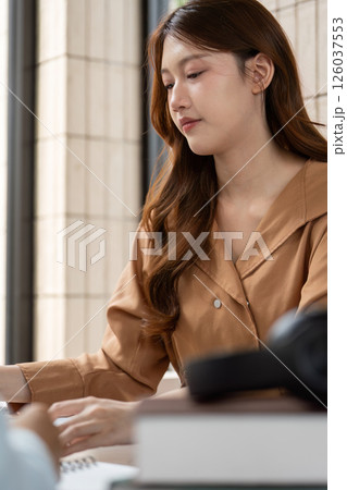 Focus and Study. A student concentrating on her study materials in a collaborative environment. Focus and Study. A student concentrating on her study materials in a collaborative environment. 126037553