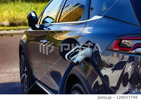 Electronic charging for electro car. EV car charging station in city. Nature eco energy. 126037749