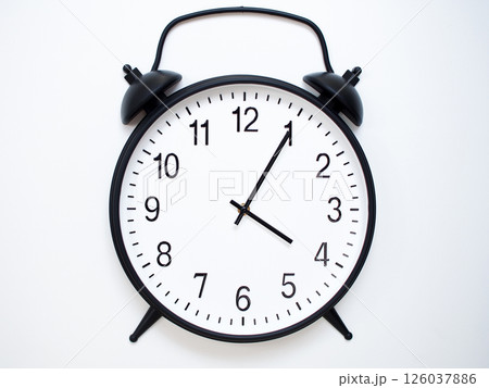 Black Retro Alarm Clock Showing 04:05 or 16:05. Classic Bell Style on White Wood Background. Black Retro Alarm Clock Showing 04:05 or 16:05. Classic Bell Style on White Wood Background. 126037886