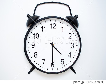 Black Retro Alarm Clock Showing 04:30 or 16:30. Classic Bell Style on White Wood Background. Black Retro Alarm Clock Showing 04:30 or 16:30. Classic Bell Style on White Wood Background. 126037891