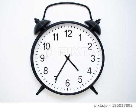 Black Retro Alarm Clock Showing 04:35 or 16:35. Classic Bell Style on White Wood Background. Black Retro Alarm Clock Showing 04:35 or 16:35. Classic Bell Style on White Wood Background. 126037892