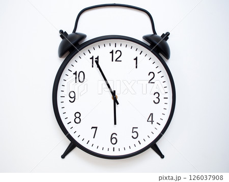 Black Retro Alarm Clock Showing 05:55 or 17:55. Classic Bell Style on White Wood Background. Black Retro Alarm Clock Showing 05:55 or 17:55. Classic Bell Style on White Wood Background. 126037908