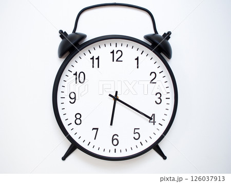 Black Retro Alarm Clock Showing 06:20 or 18:20. Classic Bell Style on White Wood Background. 126037913