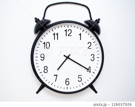 Black Retro Alarm Clock Showing 07:20 or 19:20. Classic Bell Style on White Wood Background. Black Retro Alarm Clock Showing 07:20 or 19:20. Classic Bell Style on White Wood Background. 126037926