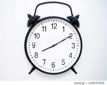 Black Retro Alarm Clock Showing 08:10 or 20:10. Classic Bell Style on White Wood Background. 126037939