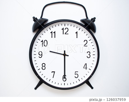Black Retro Alarm Clock Showing 09:30 or 21:30. Classic Bell Style on White Wood Background. 126037959