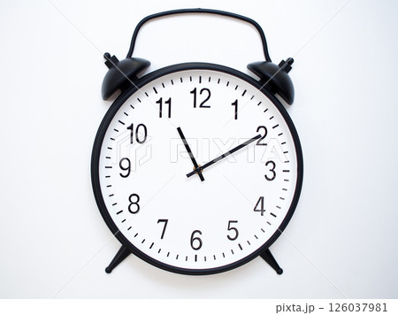 Black Retro Alarm Clock Showing 11:10 or 23:10. Classic Bell Style on White Wood Background. Black Retro Alarm Clock Showing 11:10 or 23:10. Classic Bell Style on White Wood Background. 126037981