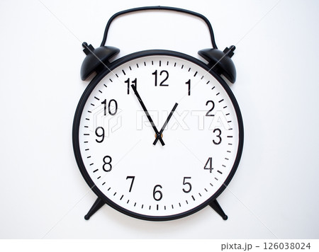 Black Retro Alarm Clock Showing 00:55 or 12:55. Classic Bell Style on White Wood Background. Black Retro Alarm Clock Showing 00:55 or 12:55. Classic Bell Style on White Wood Background. 126038024