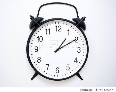 Black Retro Alarm Clock Showing 01:10 or 13:10. Classic Bell Style on White Wood Background. 126038027