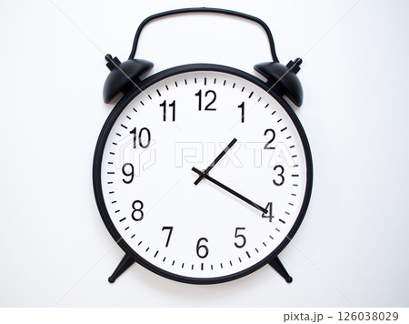 Black Retro Alarm Clock Showing 01:20 or 13:20. Classic Bell Style on White Wood Background. 126038029