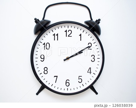 Black Retro Alarm Clock Showing 02:10 or 14:10. Classic Bell Style on White Wood Background. 126038039