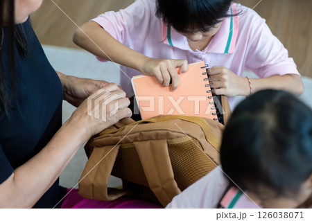 Back to School and Family Support. Kids excitedly packing their bags with a caregiver. Back to School and Family Support. Kids excitedly packing their bags with a caregiver. 126038071