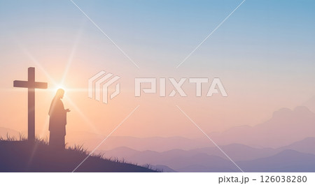 Silhouette of Jesus Praying Beside Cross at Sunrise on a Mountain Hilltop 126038280