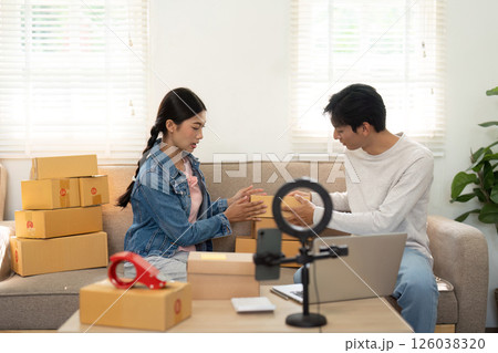 Packaging and Creativity. A couple organizing their products for an online business while sharing ideas. 126038320