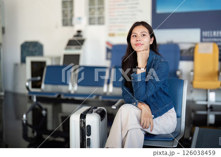 Travel journey with a woman thoughtfully waiting at the airport 126038459