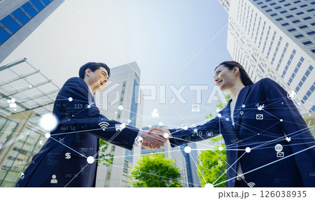 握手する男女ビジネスパーソンとデジタルテクノロジーのコンセプト 126038935