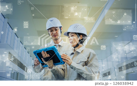 タブレットを見ながら点検する男女作業員とデジタルテクノロジーのコンセプト 126038942