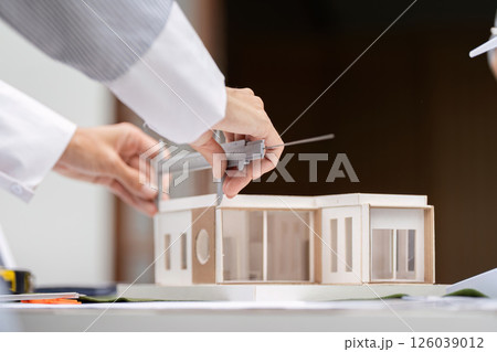 Sustainability and Measurement Techniques. Detailed view of hands using calipers on a sustainable building model. Sustainability and Measurement Techniques. Detailed view of hands using calipers on a sustainable building model. 126039012