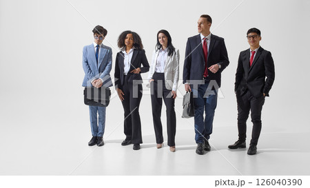 Group portrait of young, confident people dressed formal suits posing together against white studio background. 126040390