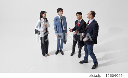 Business team converses against white studio background, illustrating business communication and policy exchange among colleagues. 126040464