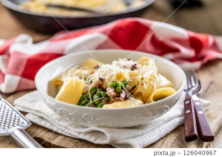 Typical Italian pasta Calamarata with bacon, fresh peas and parmesan cheese Typical Italian pasta Calamarata with bacon, fresh peas and parmesan cheese 126040967