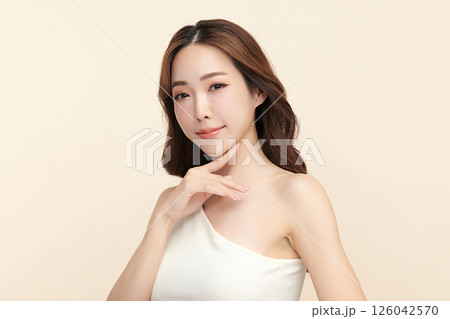 A beautiful young Asian woman with clean, fresh skin against a beige background. Skincare, facial treatment, cosmetology, beauty, and spa. An elegant portrait of an Asian woman. A beautiful young Asian woman with clean, fresh skin against a beige background. Skincare, facial treatment, cosmetology, beauty, and spa. An elegant portrait of an Asian woman. 126042570