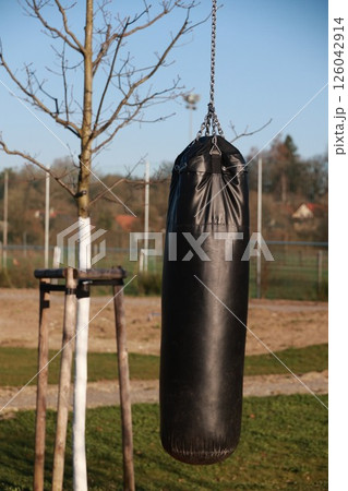 A black leather bag hanging from a chain 126042914