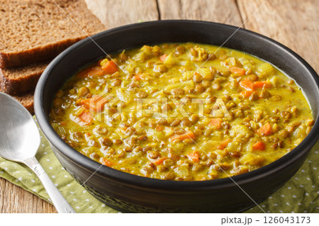 Vegan detox lentil soup with coconut milk, carrot, onion, turmeric, lemon and ginger close-up in a plate. Horizontal 126043173