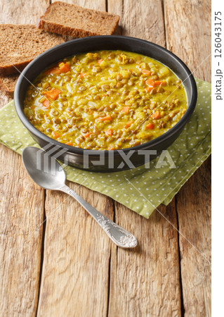 Detox lentils Soup contains anti-inflammatory ingredients like turmeric, lemon, and ginger closeup in the plate. Vertical 126043175